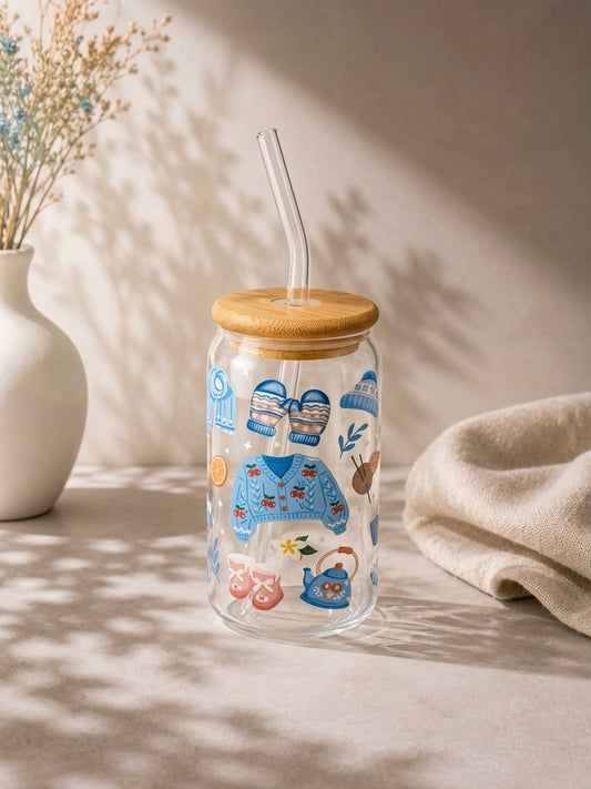 Nyt favorittdrikken din med ekstra kosestemning! Dette vakre iskaffeglasset med lokk og sugerør er dekorert med sjarmerende illustrasjoner av strikkegensere, varme votter, garnnøster og tekanner.