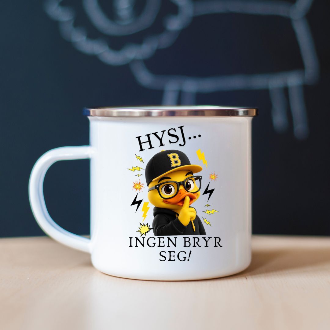 Hvitt emaljekrus med sølvkant og motiv av en gul kylling med briller, hoodie og caps som holder fingeren foran nebbet, samt teksten Hysj... Ingen bryr seg!, stående på et trebord